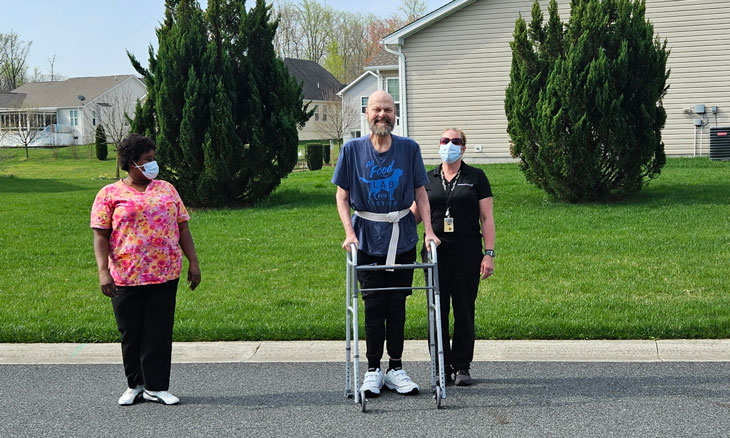 James Scharf walking with his home health care nurses