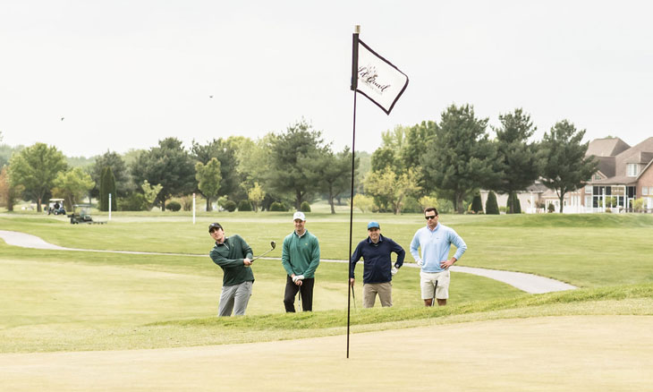 Golf foursome near putting green.