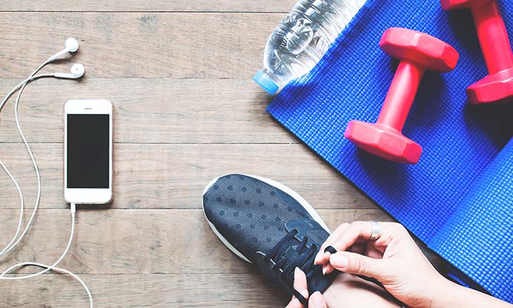 Person tying sneakers getting ready for a home workout