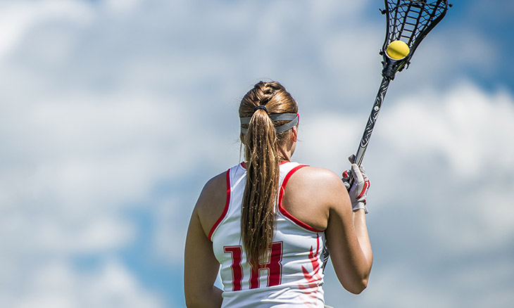 Teenage lacrosse player playing in the summer heat