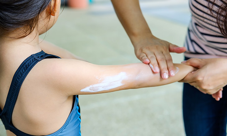 Adult applying sunscreen to a child