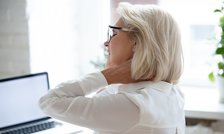 Bayhealth patient at computer with neck and back pain