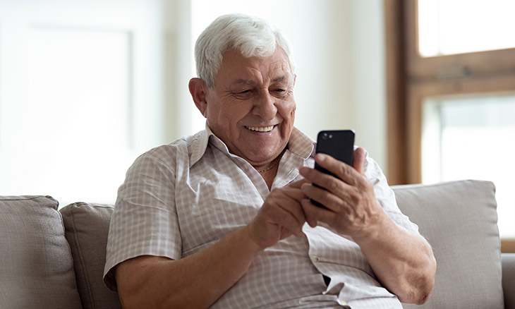 Older man talking to family on cell phone video chat