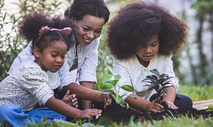 Mom and two children outside gardening together