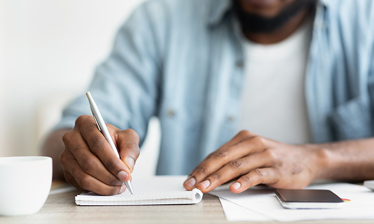 Man writing list of New Year's resolutions