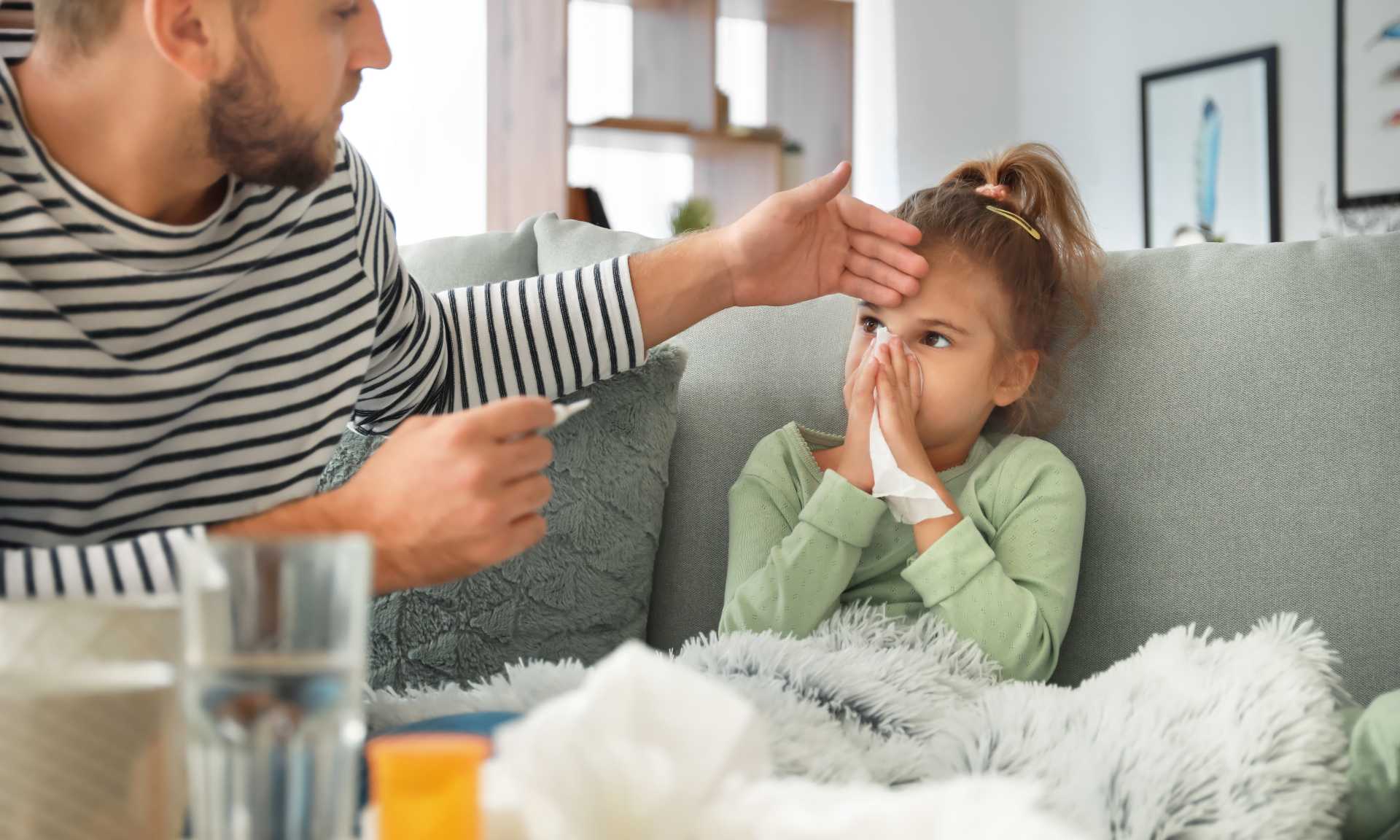 Father touching the head of sick child to feel for fever