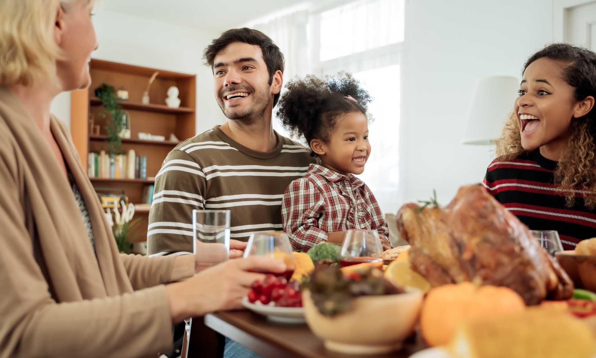 Family with young child enjoying Thanksgiving meal.