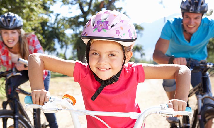 Child uses helmet to stay safe while riding her bike