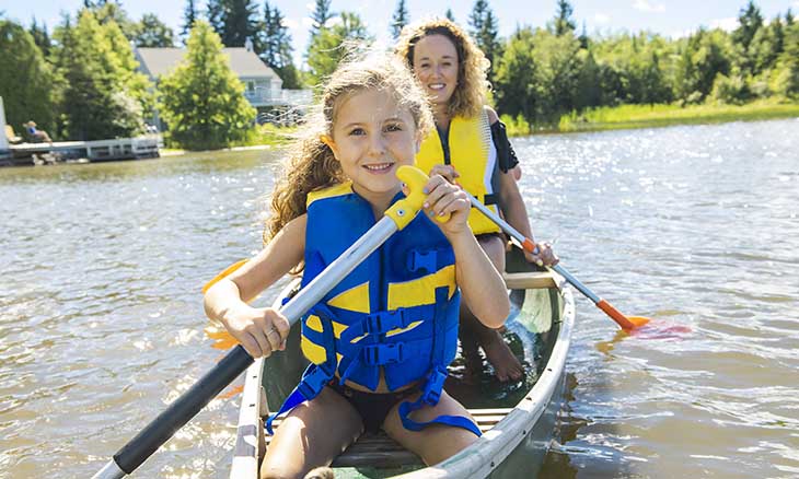 Child wears life jacket in canoe