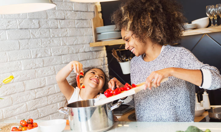 Mom cooking vegetables with her daughter.