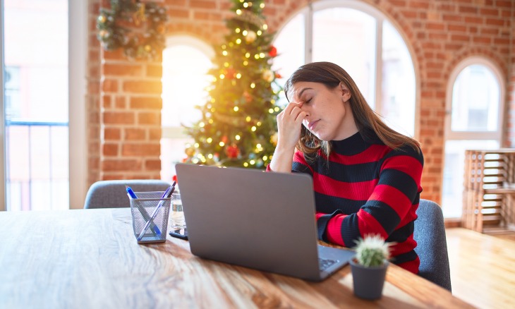 A woman sits in front of a laptop.