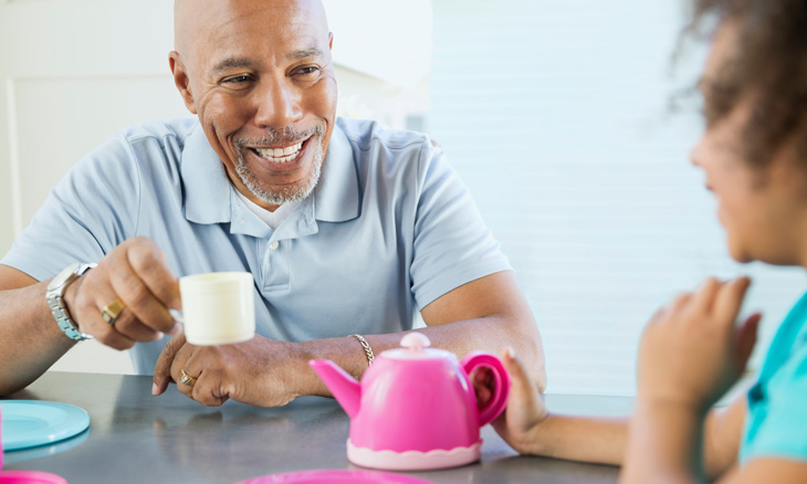 Grandfather playing tea with granddaughter