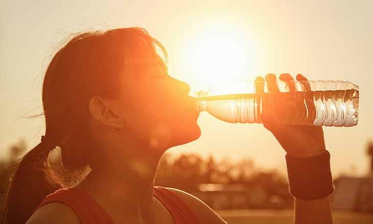 Woman drinking water in the sun