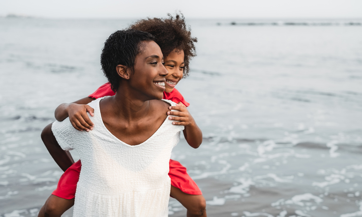 Mother playing with her daughter at the beach