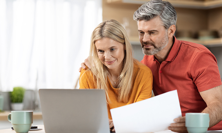 A couple looks at a laptop.
