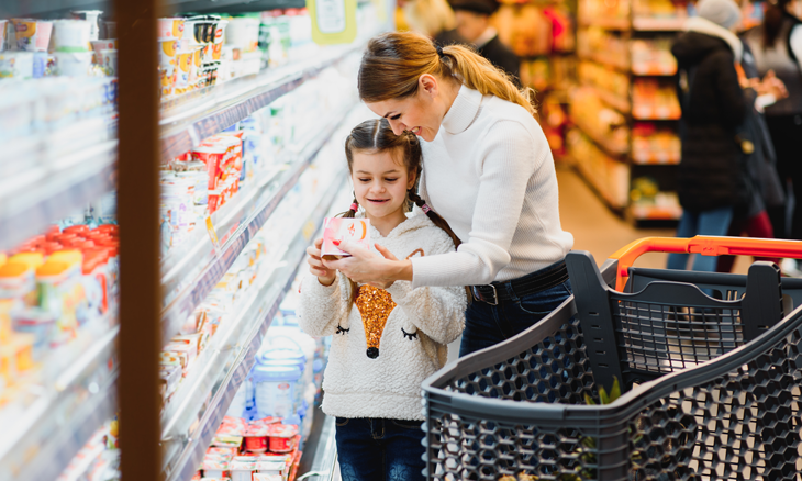 Mother showing her child health foods in a grocery store