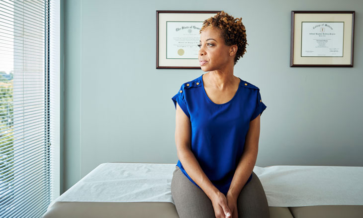 Women stares out the window at a doctors visit.