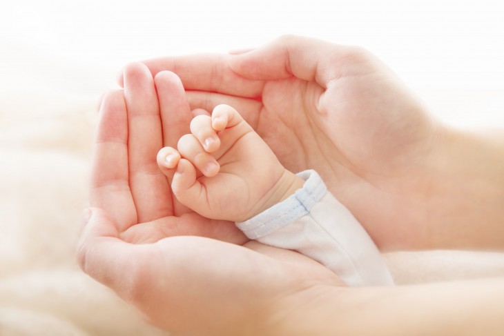 Infant hand in adult hands