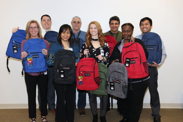 Information Technology team members with backpack donations