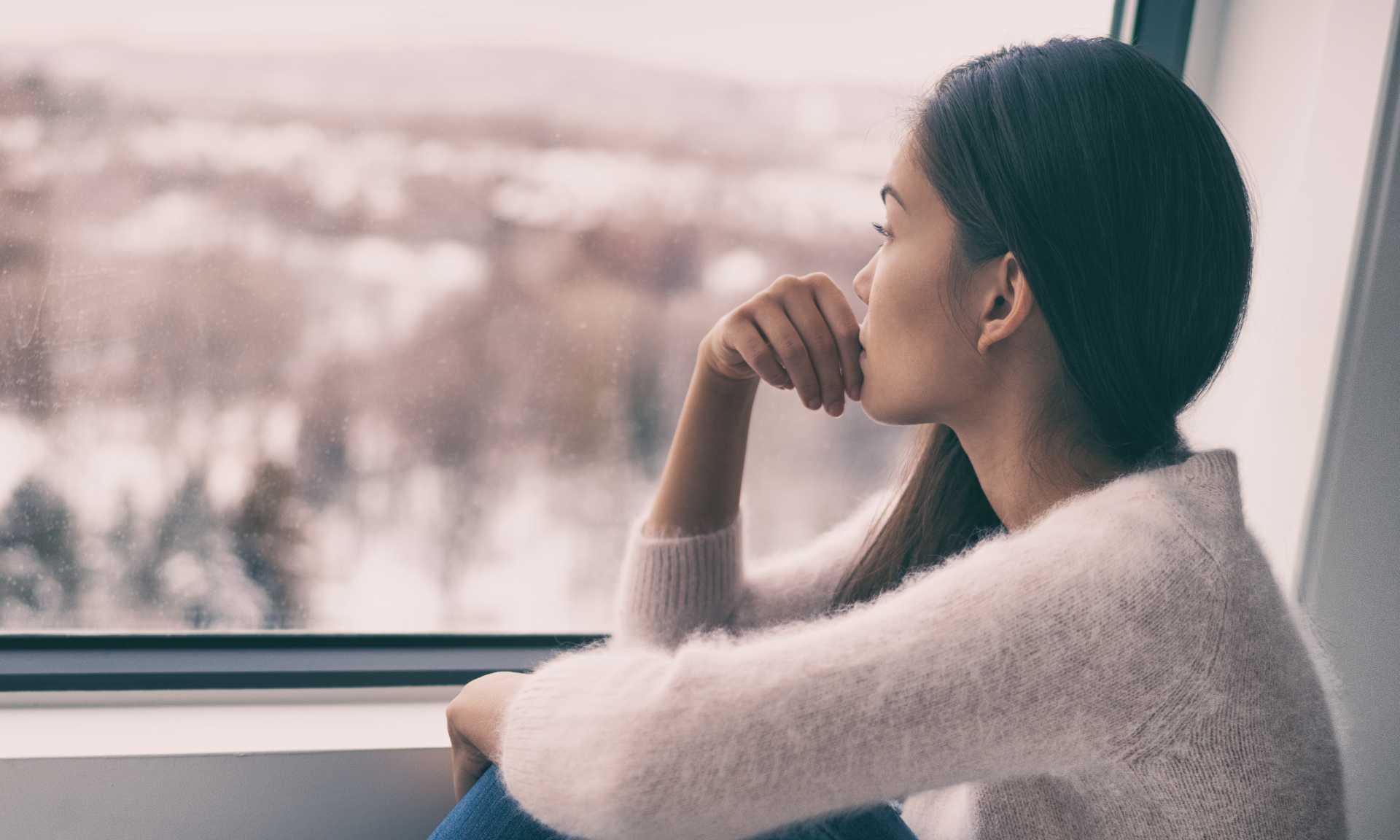 Woman looking out the window during wintertime