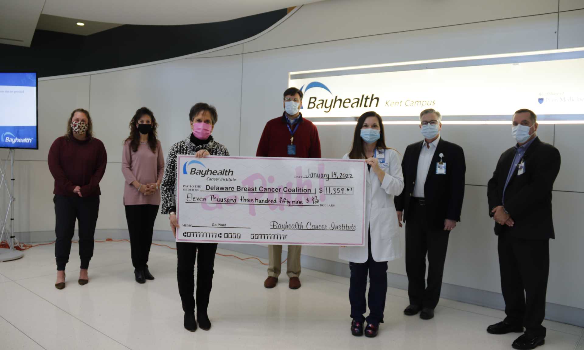 Representatives from Bayhealth and Delaware Breast Cancer Coalition hold a large check representing monies raised from the Go Pink fundraiser.