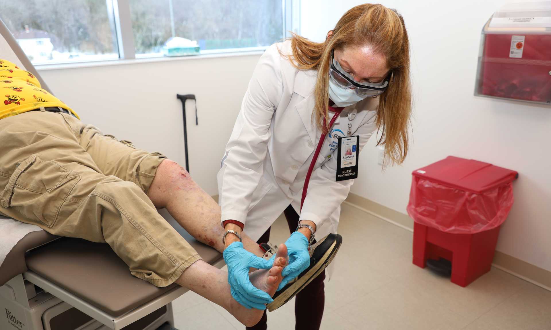 Bayhealth Nurse Practitioner Roseann Velez examines a patient's foot during his appointment. 