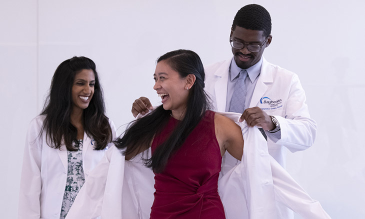 A new resident physician receives her white coat.