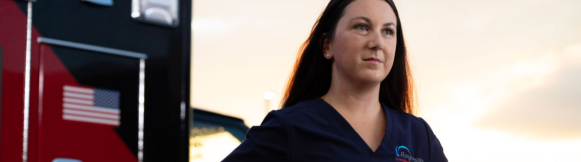 Nurse stands in front of ambulance