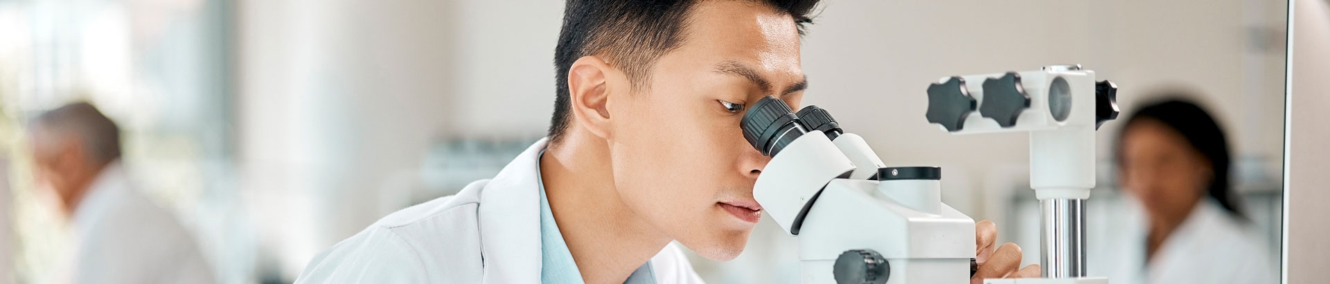 Bayhealth employee looking in microscope