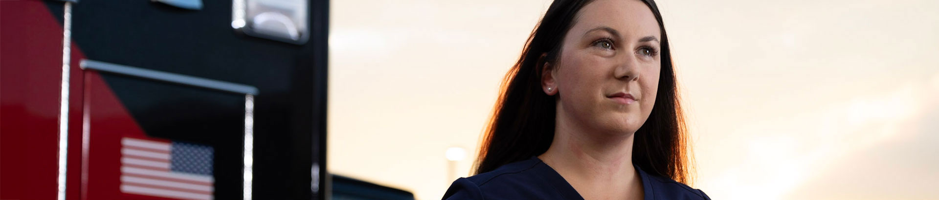 Nurse standing outside of emergency room in front of an ambulance
