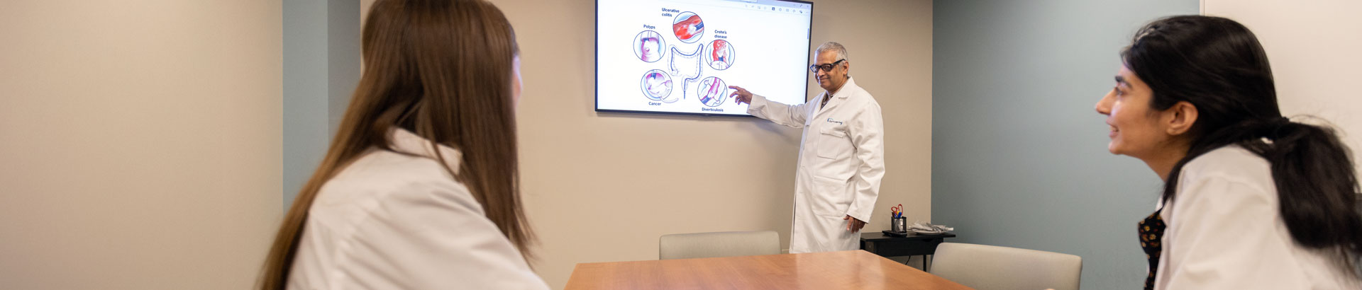 Two gastroenterology residents listening to faculty lecture