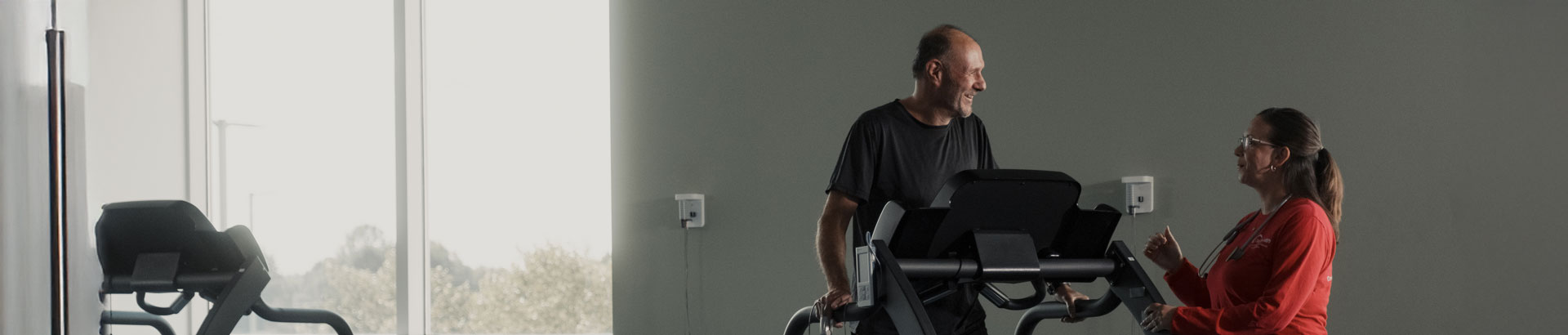 Patient walking on treadmill with cardiopulmonary rehabilitation specialist.