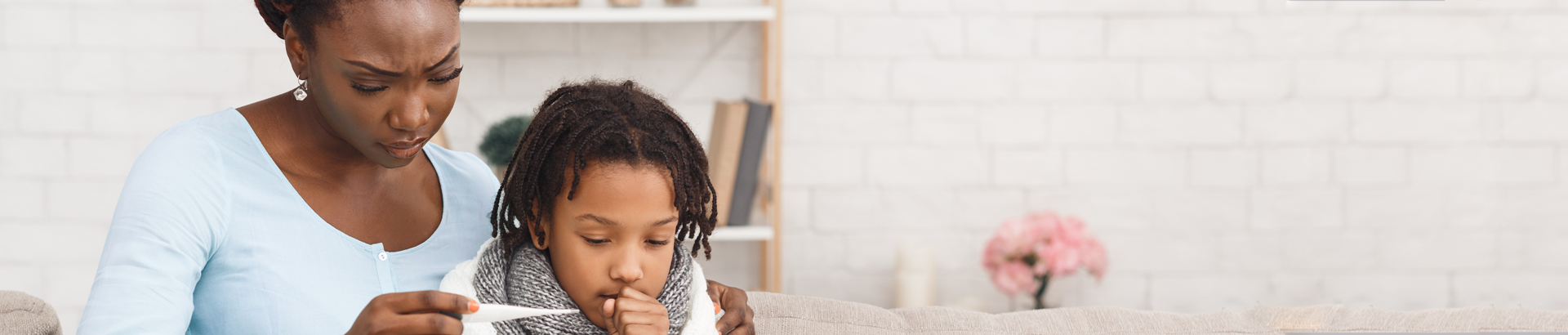 Mother checking the temperature of her sick child.