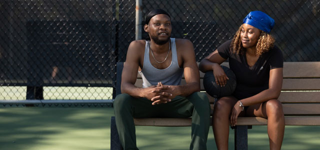 Couple sitting on a bench at basketball courts