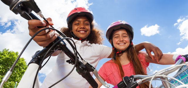 Two girls on bikes smiling