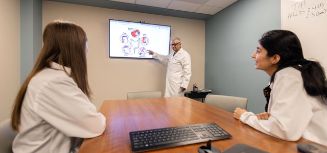 Two gastroenterology residents listening to faculty lecture