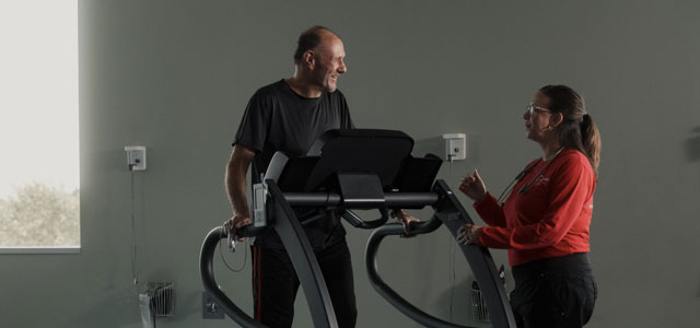 Patient walking on treadmill at cardiopulmonary rehabilitation center.