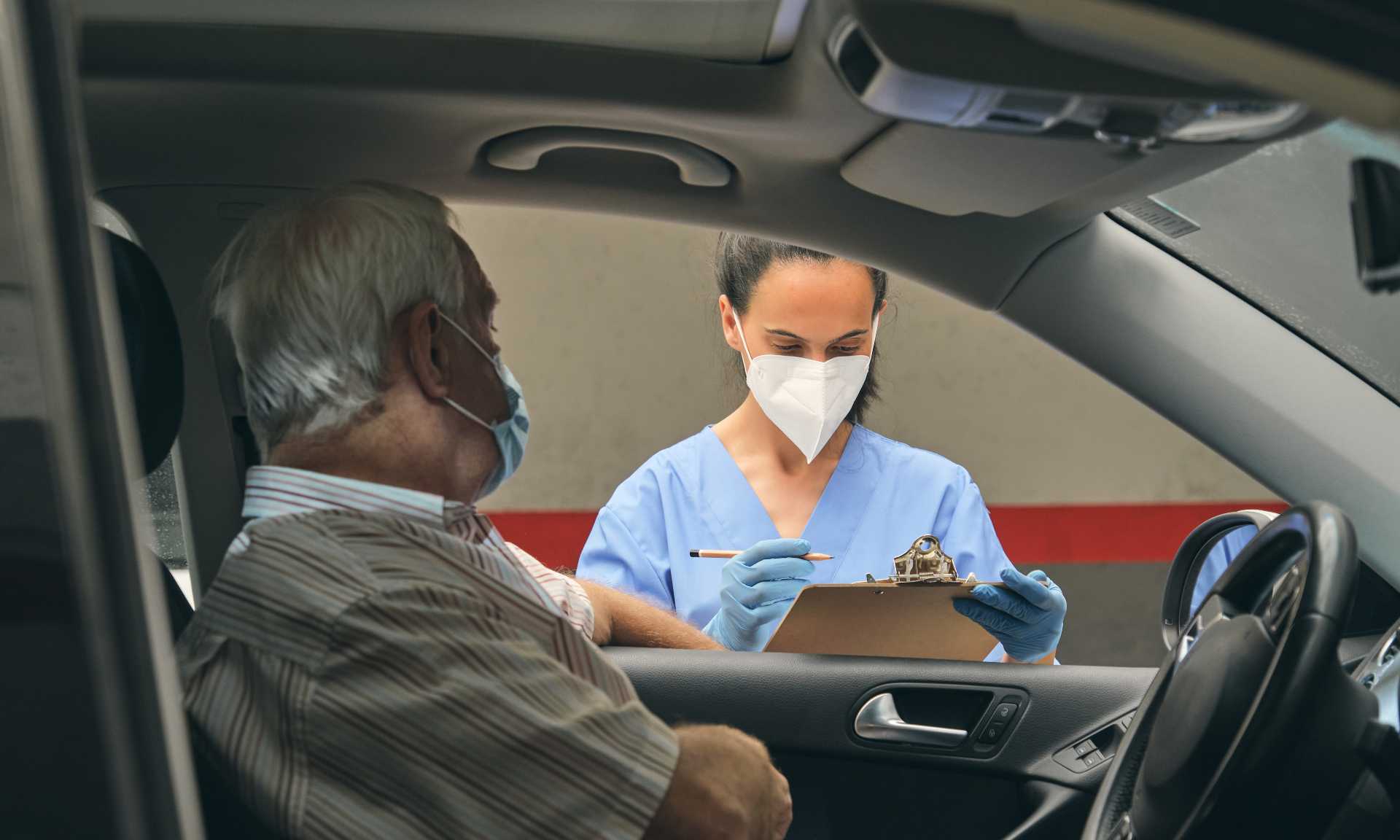 Man in car waiting for clinician at drive thru COVID-19 testing