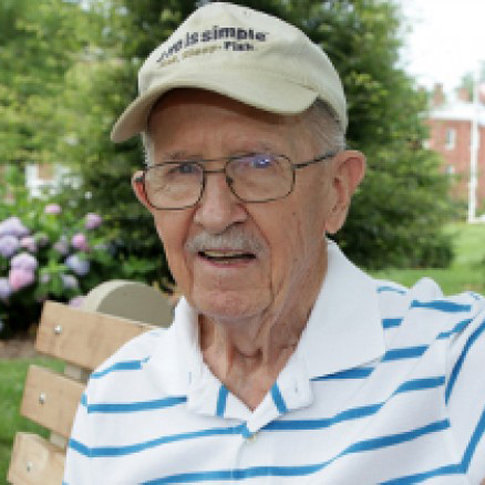 TAVR patient Mike Connelly sits on a bench in a park